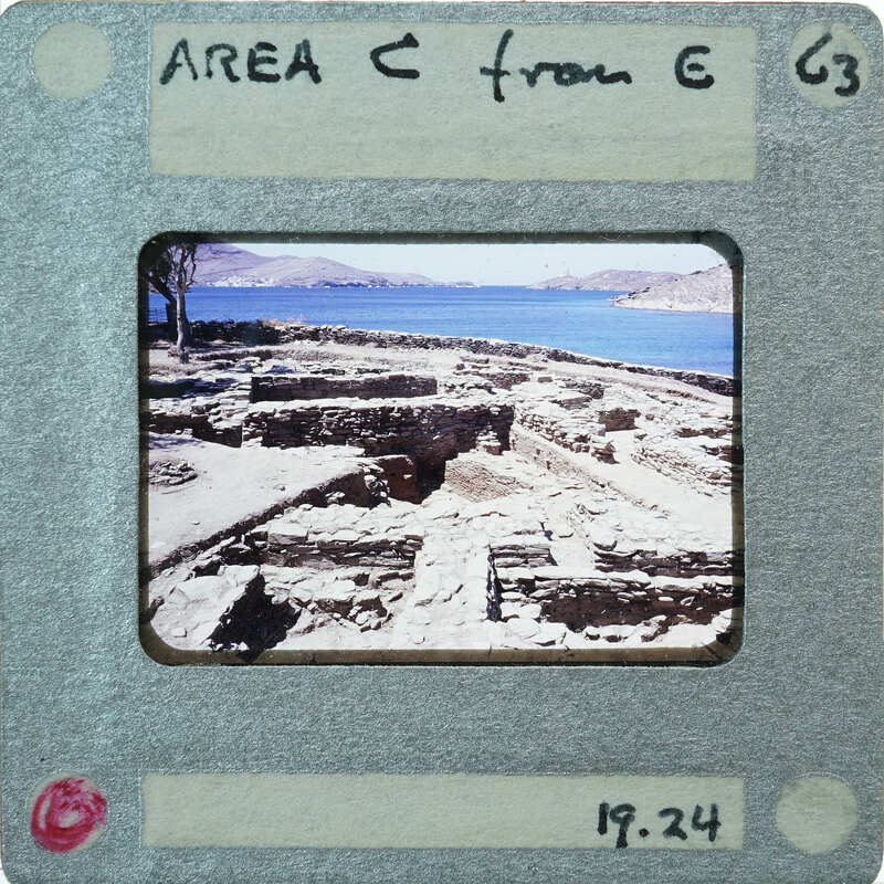 A photograph of an ancient archaeological site next to a body of water, with ruins and the sea visible.