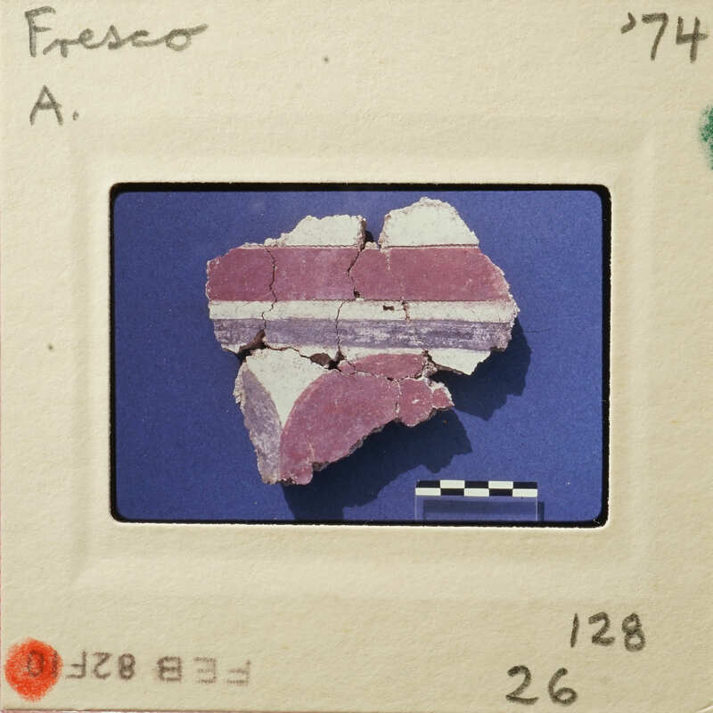 A photograph of an artifact, possibly pottery, with visible cracks and layers on a blue background.