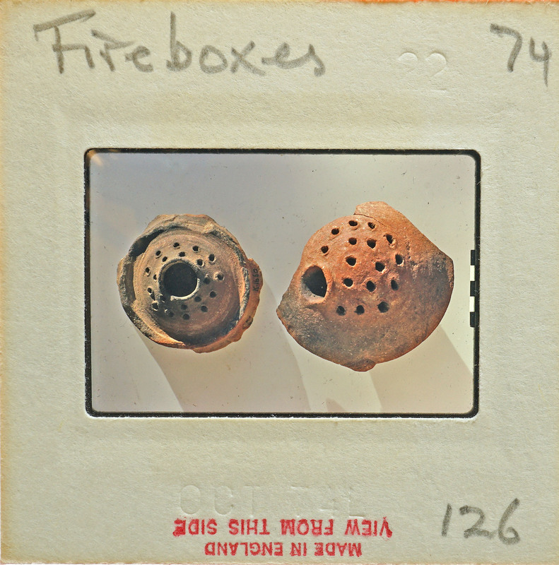 Two antique fireboxes on display with holes and textured surfaces.