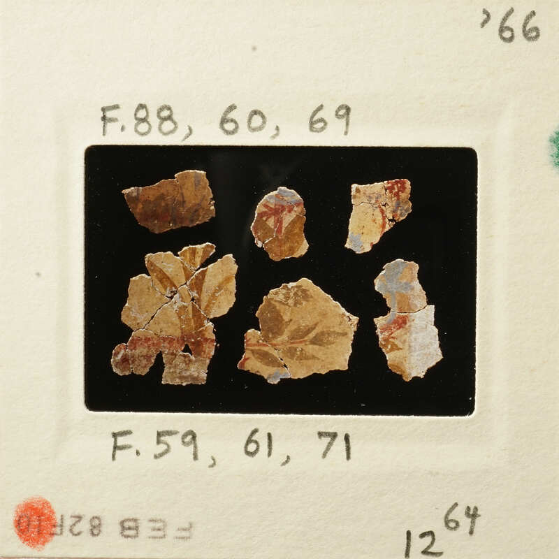 Photograph of ancient pottery shards with visible markings and colors.