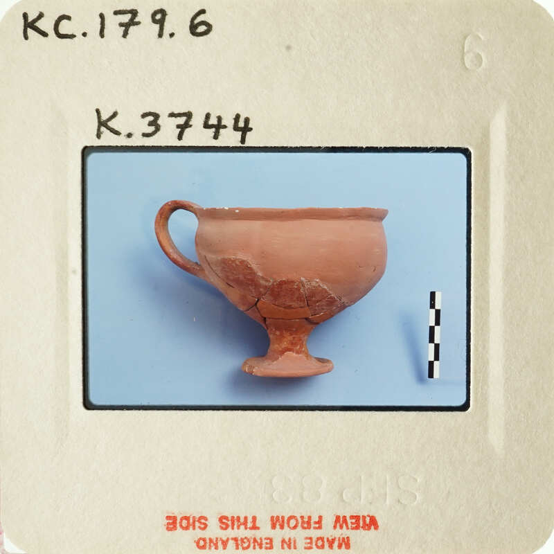 Ancient Greek amphora with visible cracks and wear, displayed on a blue background.