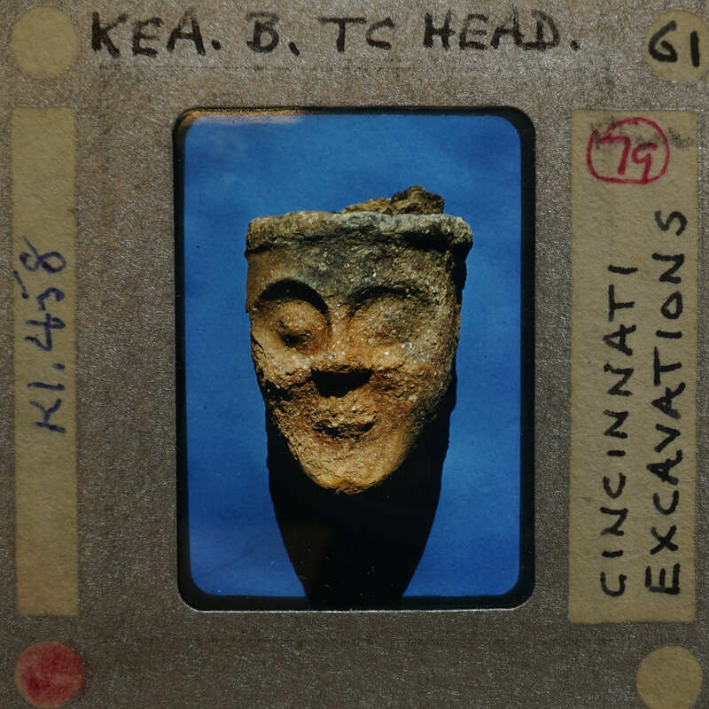 Fragment of broken terracotta head from front; figurine K1.458.