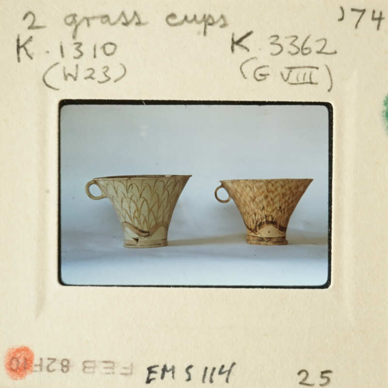 Two antique cups with handles on display.
