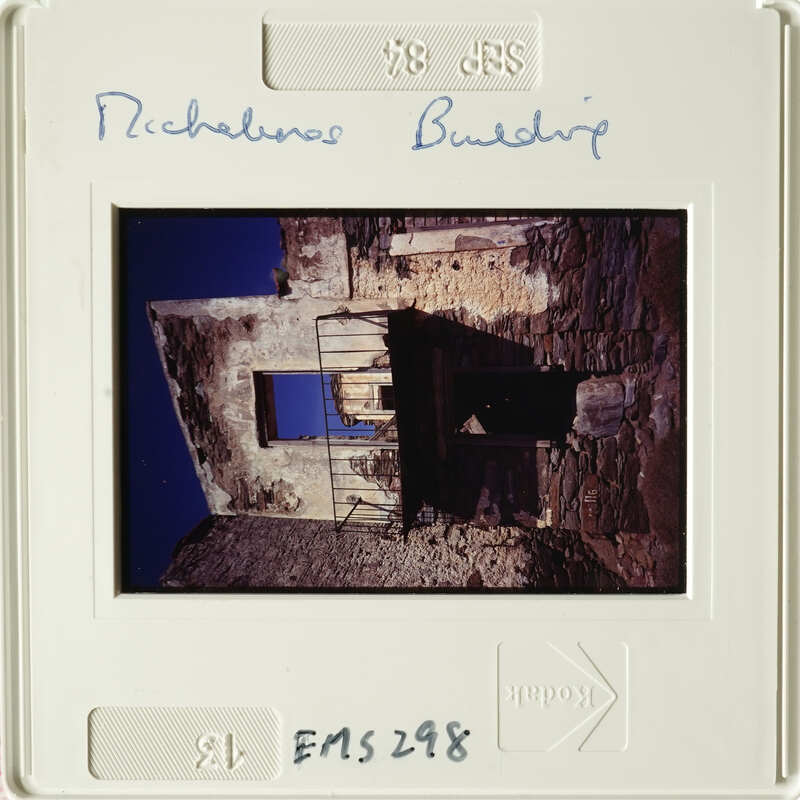 A photograph of an abandoned building with a dark interior and sky visible through its openings.