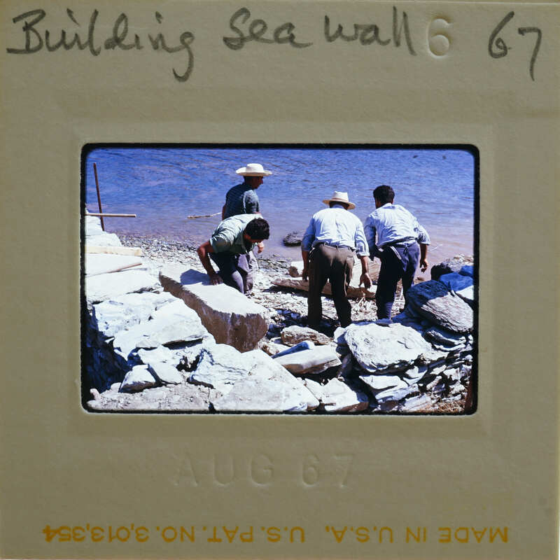 A vintage photograph of three men working on a sea wall, possibly dated August 1967.