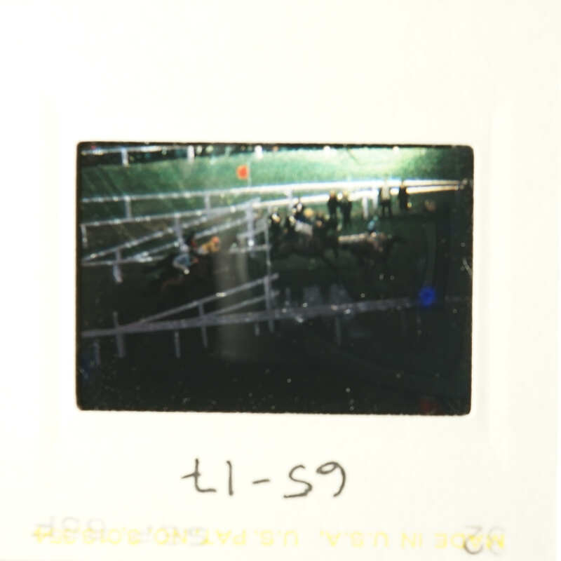 Picture of a horse race with jockeys on horses.