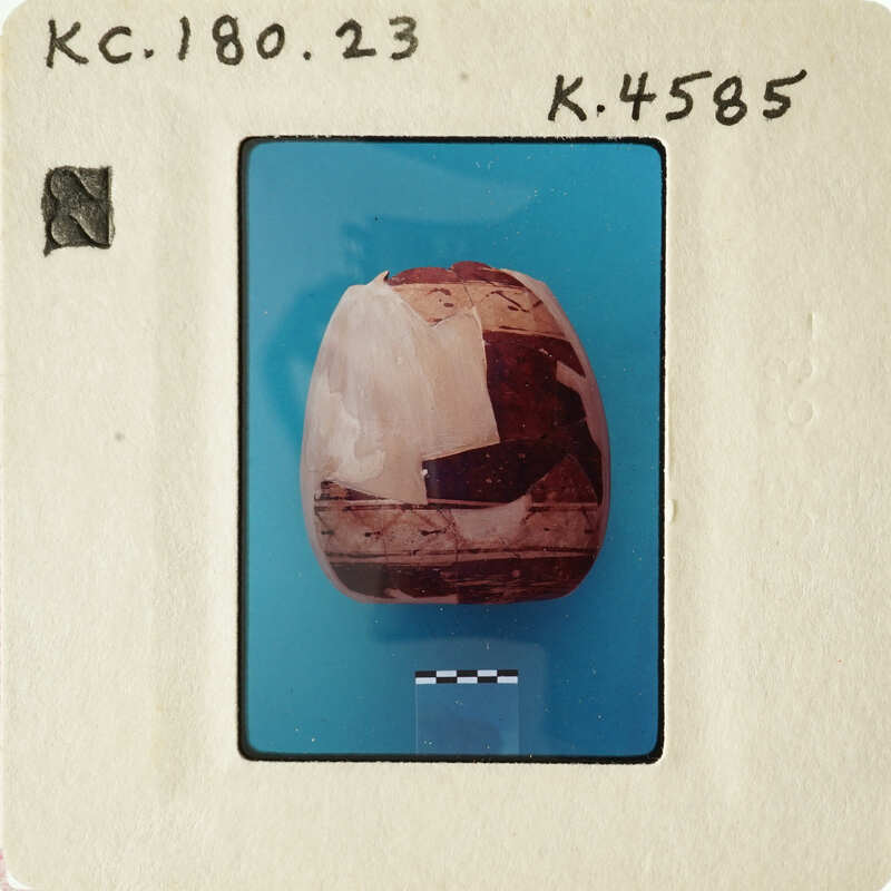 A close-up photograph of an object with a cracked surface, possibly a stone or artifact, displayed on a blue background.