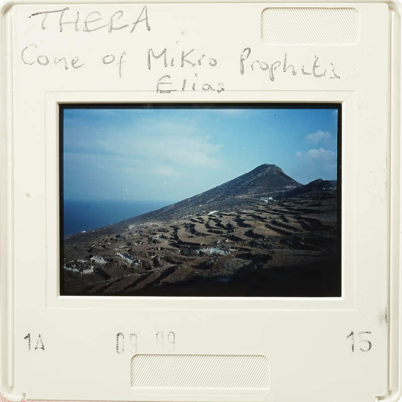 Mountainside landscape with terraced fields and buildings, as seen through an old photograph.
