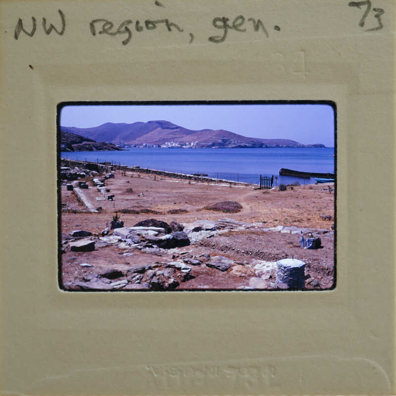An old photo of a coastal archaeological site with ruins and the sea in the background, framed by an aged film strip.