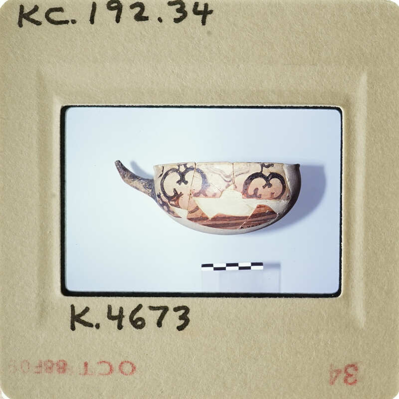 A photograph of an antique bowl with intricate designs on a white background.