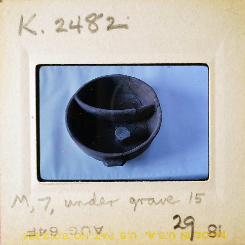 An old, cracked clay pot with a handle.