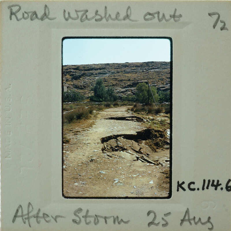 A damaged dirt road with a large crack, possibly due to heavy rain or flooding, as indicated by the photo's caption and date stamp.