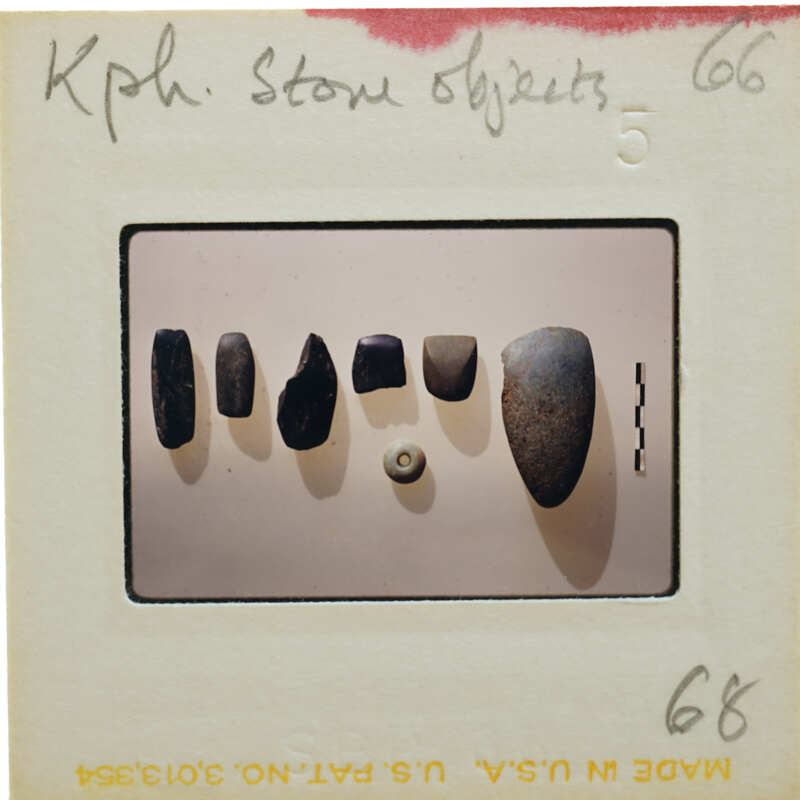 This is a photograph of a collection of stone objects displayed on a white surface.