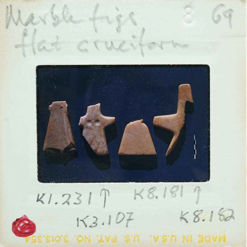 Image of a collection of small marble figurines, possibly ancient artifacts, with labels.