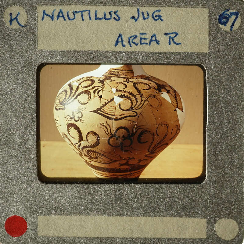 A photograph of an antique vase with intricate designs on display.