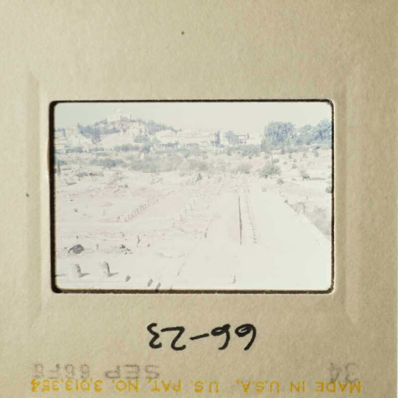 This is an image of a film strip with a view of an arid landscape and a building.