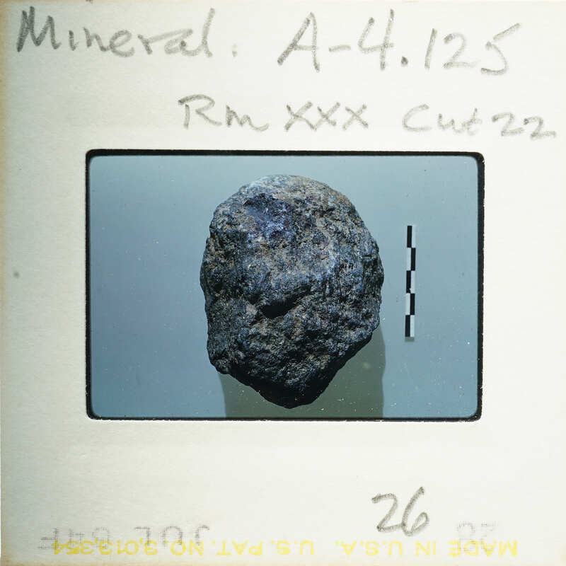A photograph of a rock on film with annotations and numbers written on it.