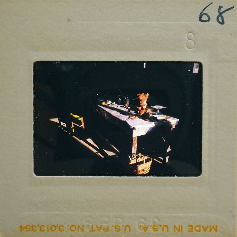 This is a photo of an old-fashioned kitchen with a table and various items on it, including what appears to be a dog.