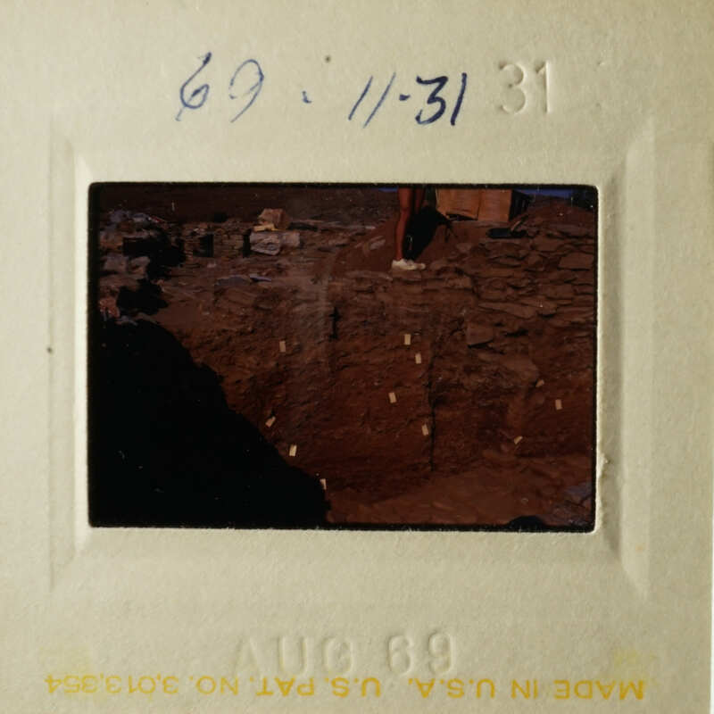 A black and white photo showing an archeological site with various artifacts.