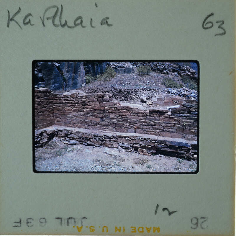 An old stone structure with a weathered appearance, possibly ruins, set against a natural landscape.