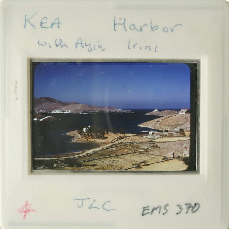 Beautiful harbor scene with clear blue water and distant mountains, captured on an old photographic slide.