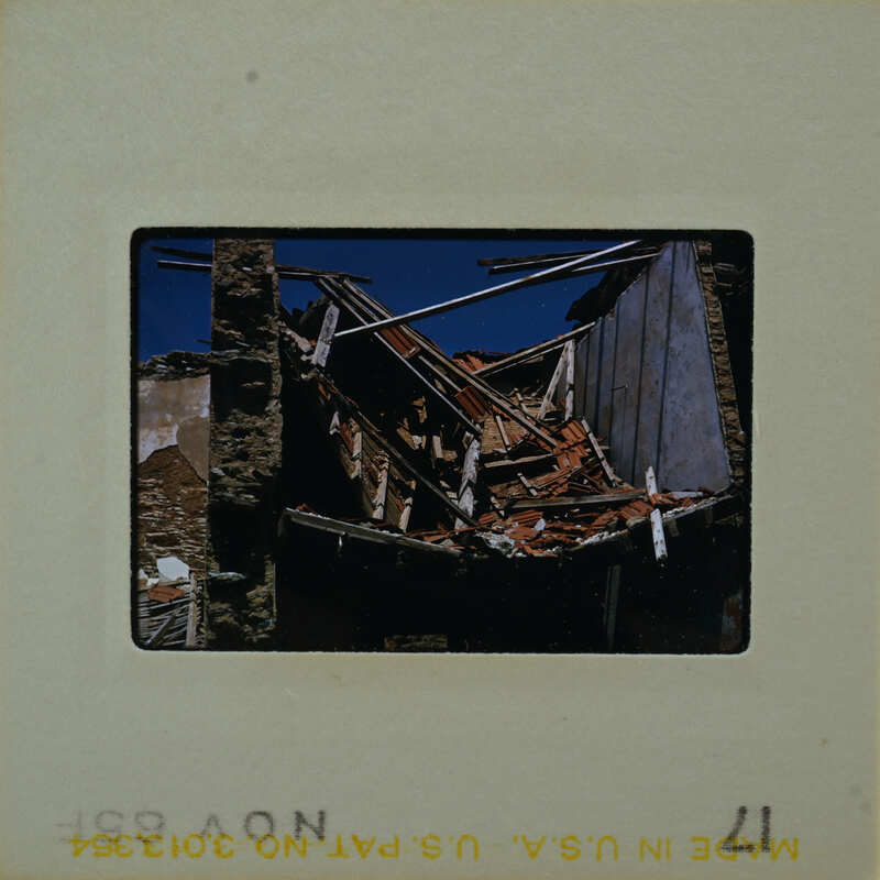 A photograph of a damaged building with exposed interior and debris.