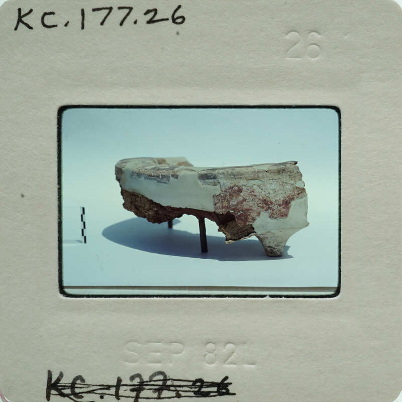 A photograph of a broken, multicolored ceramic object on display.