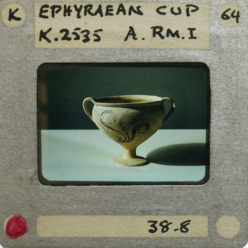 Ornate, antique cup (K.2535) on pedestal with two handles and intricate designs.