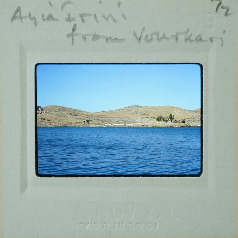 A vintage postcard showing a scenic view of a lake with mountains in the background and handwritten notes on it.