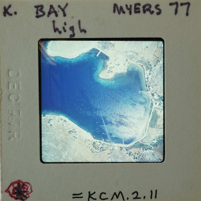 Aerial photograph of a coastal area with blue water and land features.