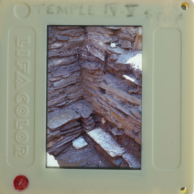 A photograph of a stone structure displayed on a transparent plastic card with printed labels around the edges.