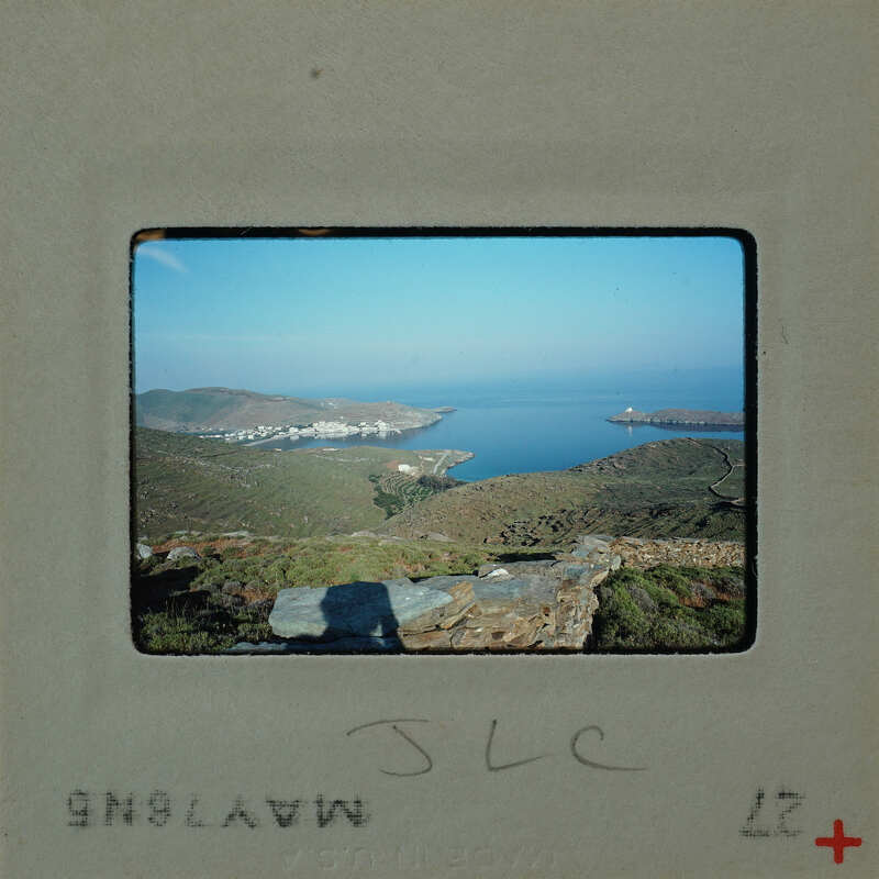 A photograph of a coastal landscape with mountains and a body of water.