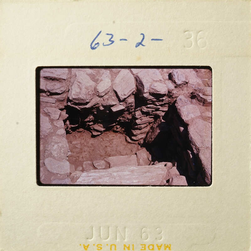 Old photograph showing an underground cave with stone walls and floor.