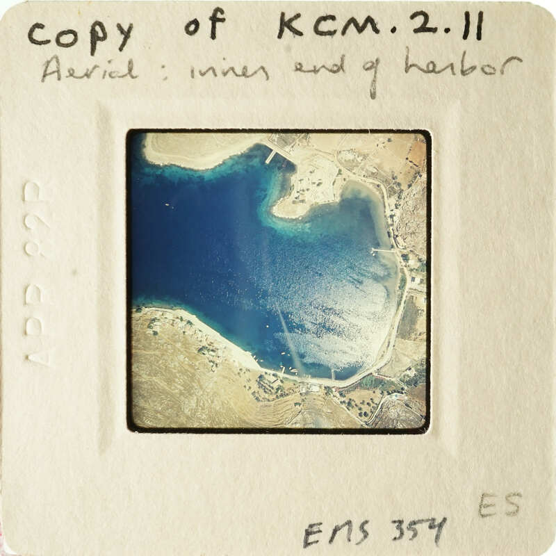 Aerial photograph of a coastal area with blue water and land formations.