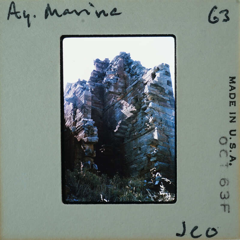 A vintage photo of a rocky cliff with handwritten notes on the border.