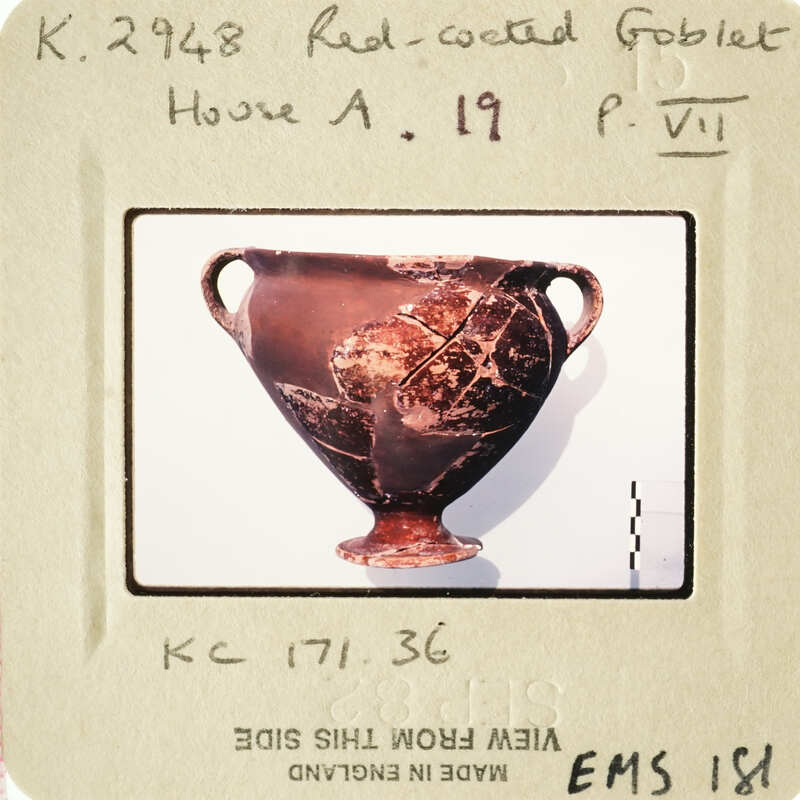 Ancient Greek vase with red-figure technique and black glaze, displayed on white stand.