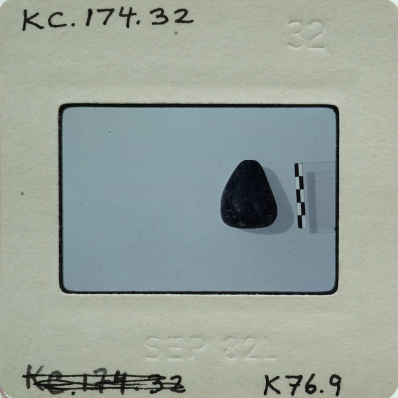 Small black rock on a white surface..