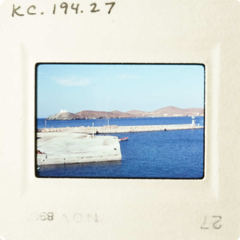 A slide showing an ocean view with a pier and boats in the background.