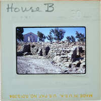 A photograph of a stone ruins with trees and a building behind it, labeled as "House B" on the front.