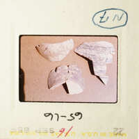 The image shows three broken pottery pieces on a table.