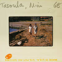 Two people walking together on a dirt path near water, with a vintage photo label indicating it's from 1968 and taken in Tofino, BC.