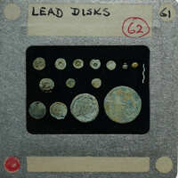 Collection of circular lead pieces on a display card.