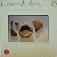 An image of a broken clay pot with fragments on display, taken from an old photograph.