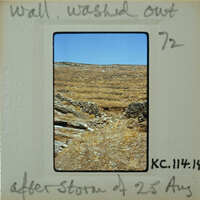 A vintage photograph of a barren landscape with a dirt path and sparse vegetation, taken on August 29th.