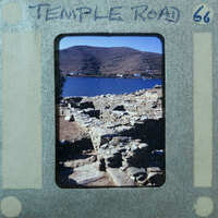 Various stone walls with water and mountains in the background.