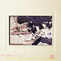 The photo shows an old stone structure, possibly ruins or a historical site, with a person standing in front of it.