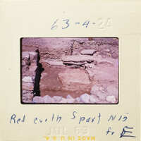 Ancient ruins with stone foundations and walls, partially excavated from the earth.