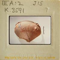 Ancient artifact, possibly pottery with visible cracks and markings.