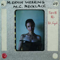 A vintage film clipping featuring a woman wearing a necklace, with handwritten notes on the border.