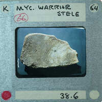 Flat stone fragment of marble with carving of man in helmet.